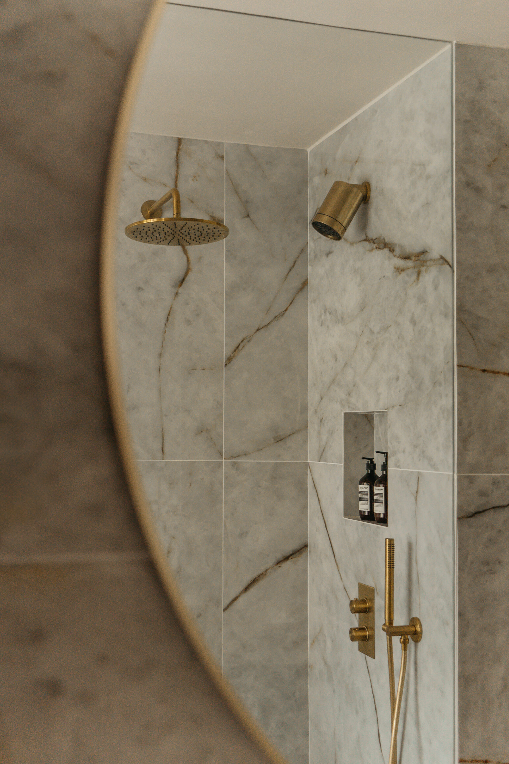 Grootformaat Himalaya Crystal polished wandtegels gecombineerd met Cream Luna vloertegels, geborsteld goud en donker houten maatwerkmeubel