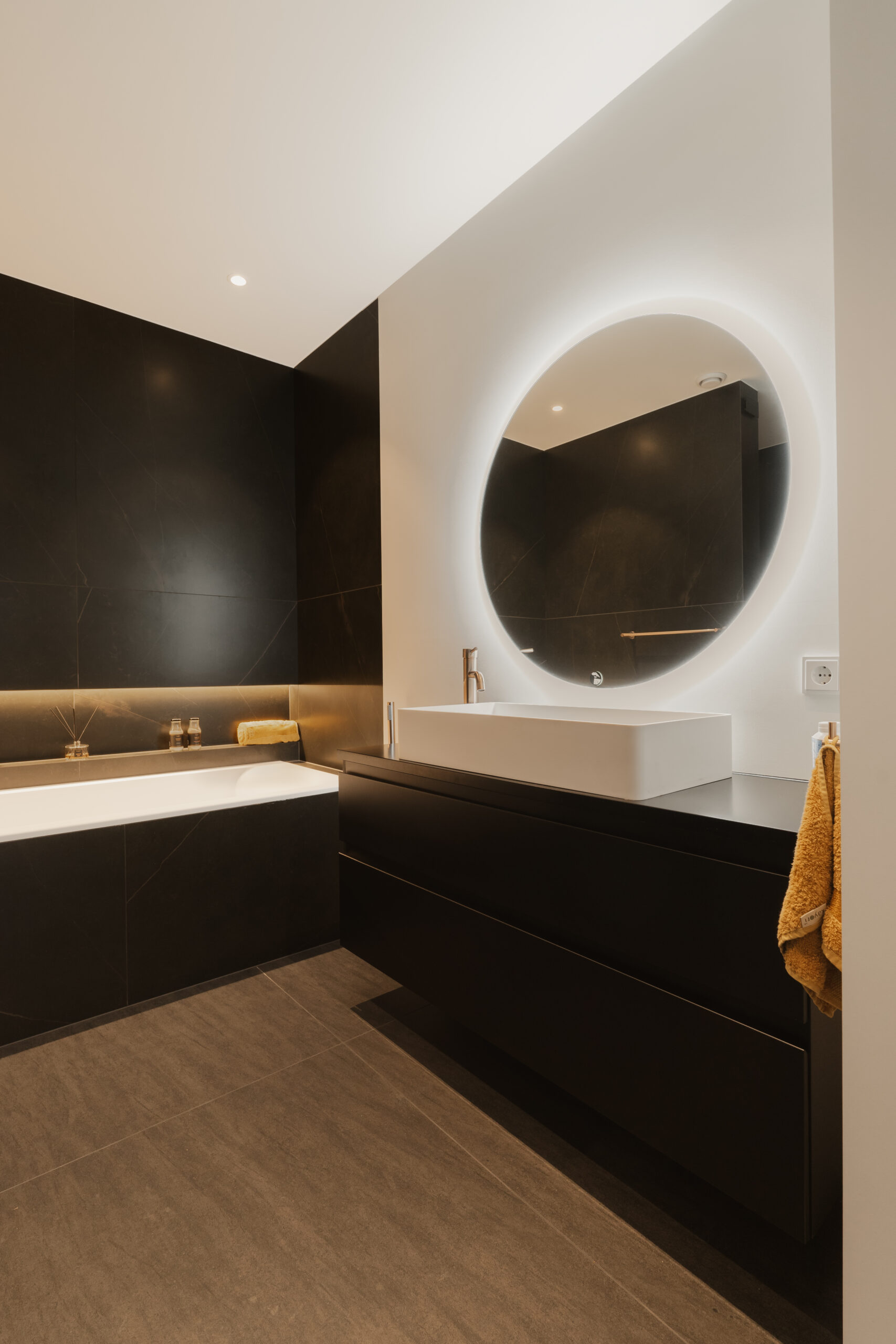 donkere badkamer met spiegel en bad